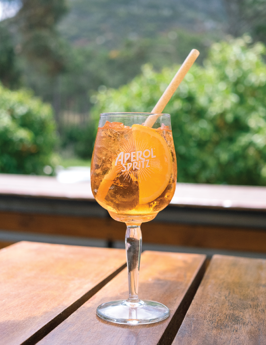 An Aperol glass with an eco-straw for sipping