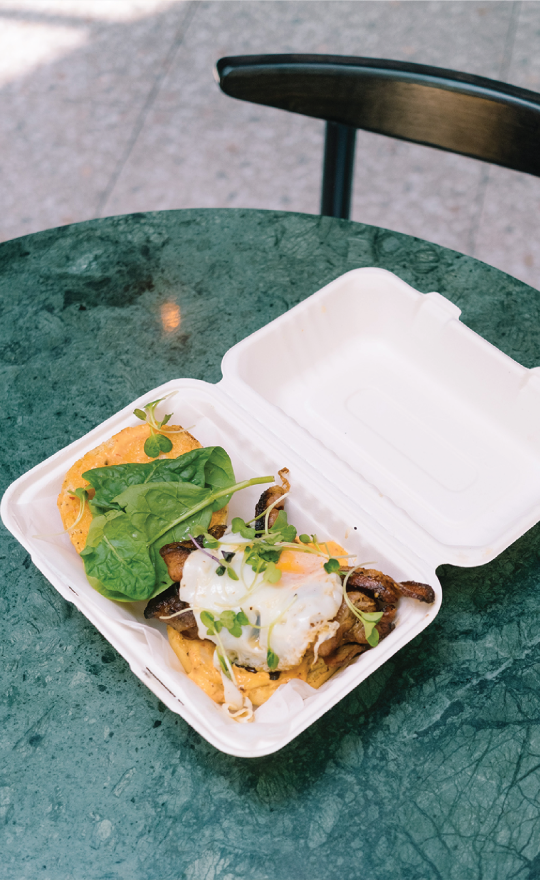 A takeaway container with eggs inside of it, the packaging is compostable.